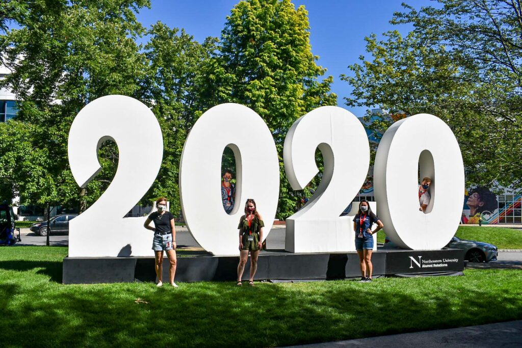 Student leaders standing in front of the 2020 sign on Centennial