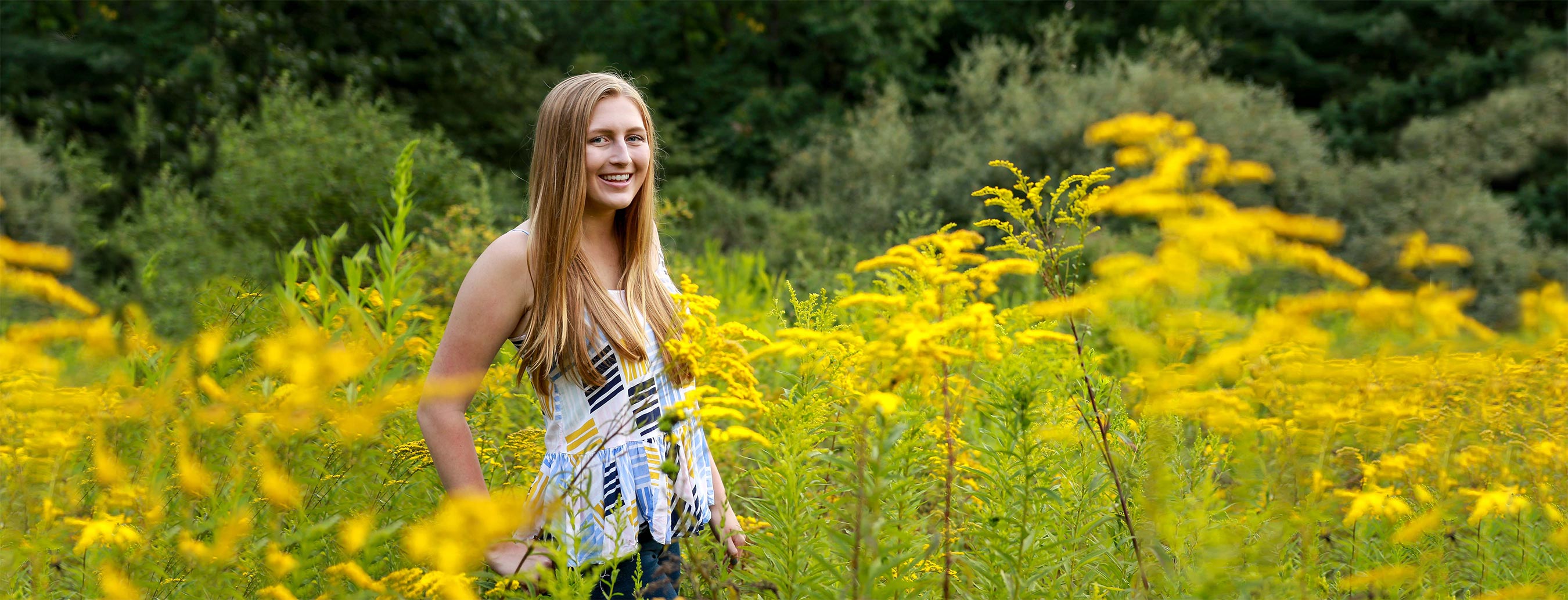 Karleigh standing in a field of flowers