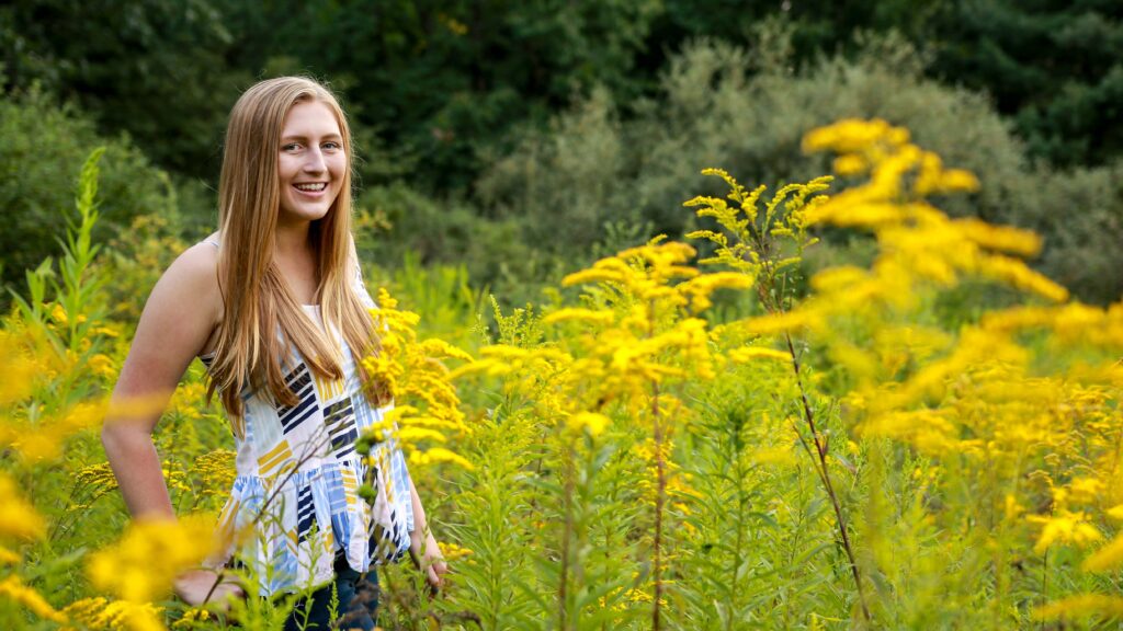 Karleigh standing in a field of flowers