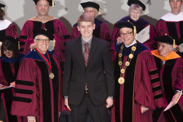 Provost and Senior Vice President for Academic Affairs Stephen Director, left, and President Joseph E. Aoun, right, recognize Moran in 2015